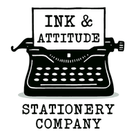 Black vintage typewriter with paper reading Ink & Attitude above the words stationery company in bold font